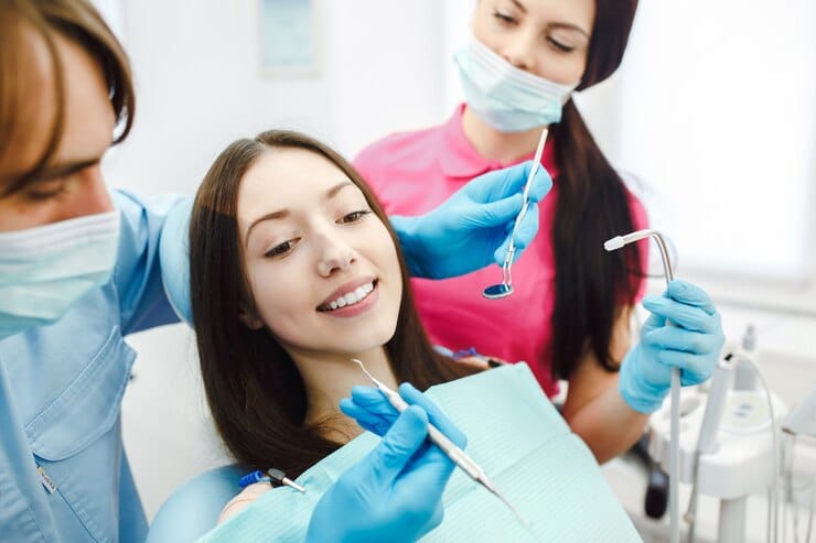 A woman receiving a dental cleaning at Alfred Cheng Orthodontic Clinic, showcasing professional dental care.